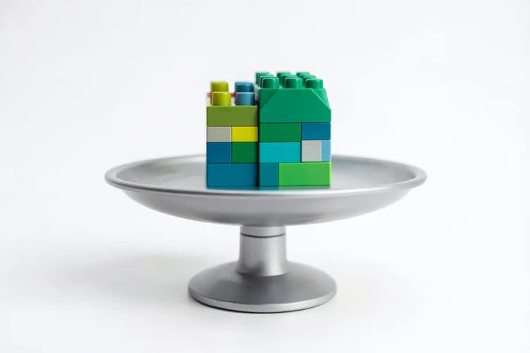 Seção 2: Símbolo de balança da justiça com um bloco de construção colorido em cima, em fundo branco.