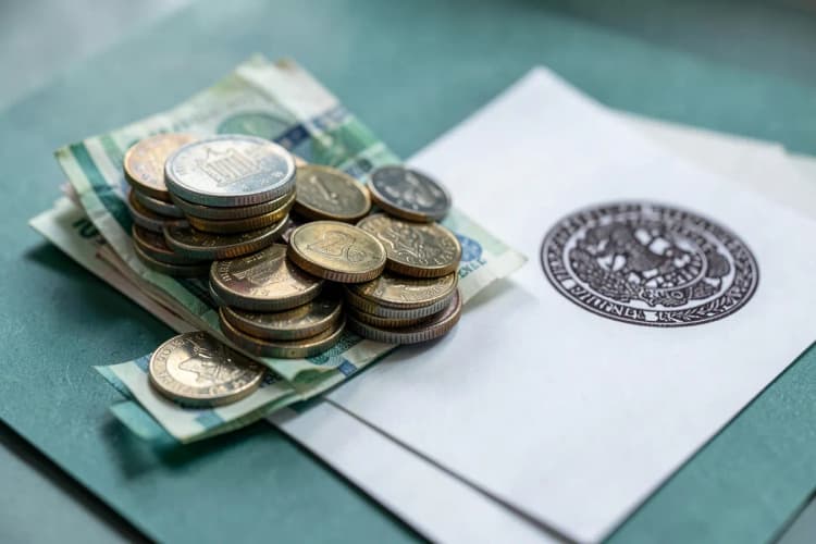 Uma pilha de moedas e notas de dinheiro ao lado de um documento com um selo.